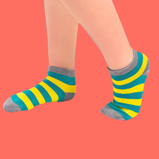 Green and yellow striped socks with gray toes and cuffs on a blue background
